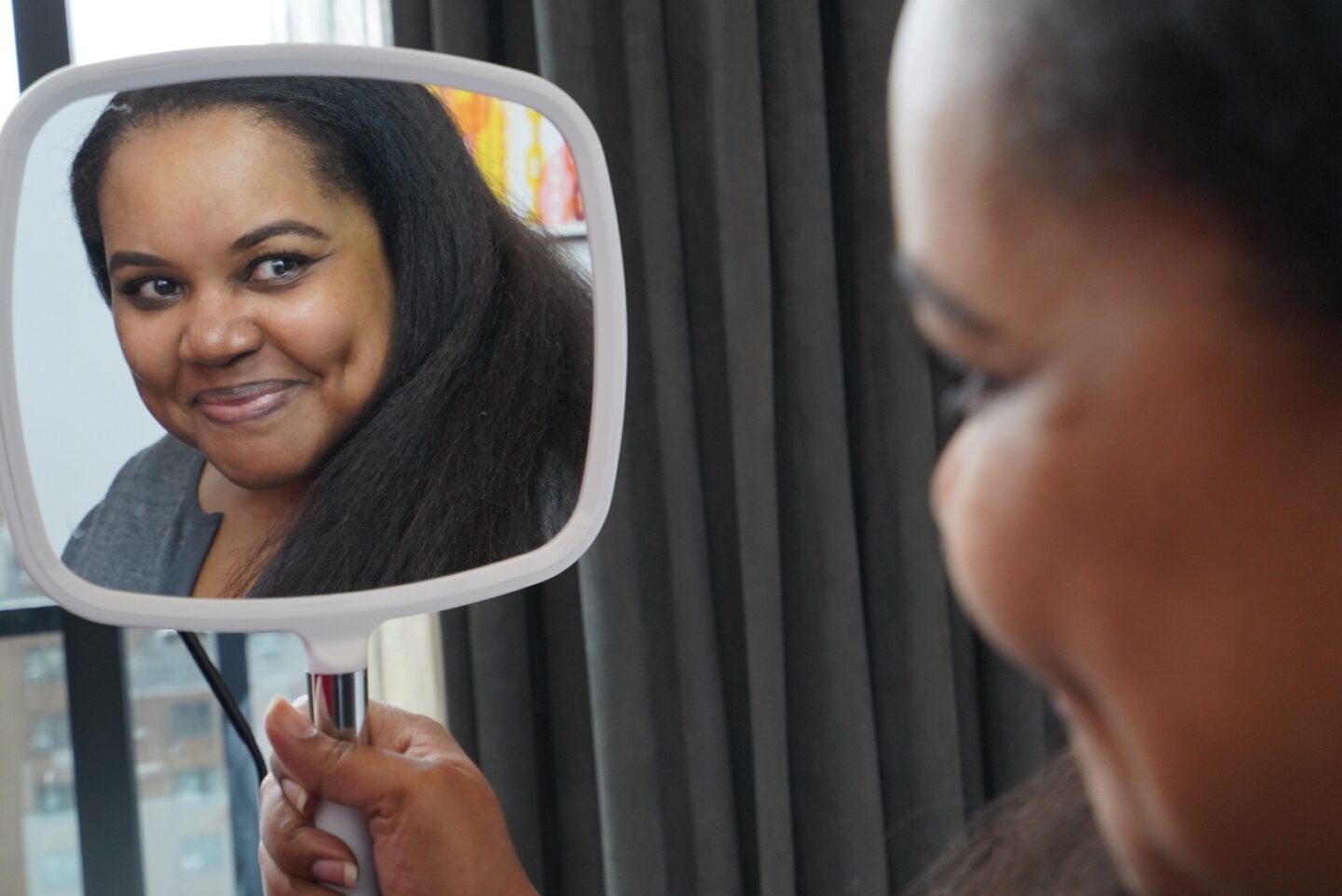 young woman looking in a handheld mirror