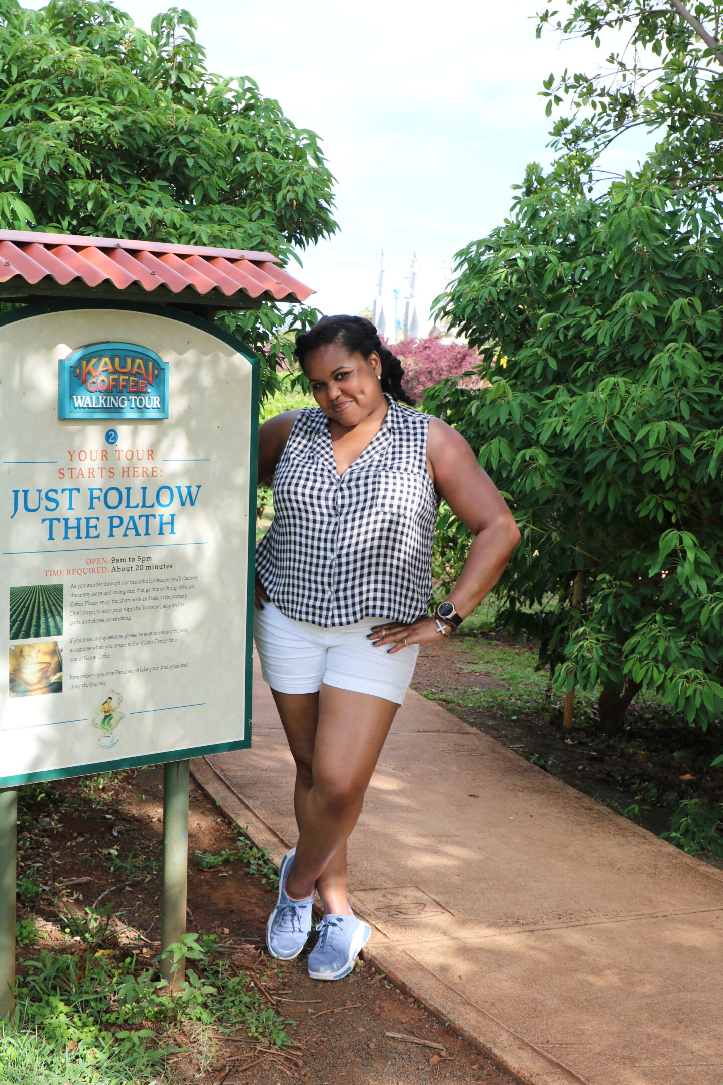 patranila stands beside kauai coffee walking tour sign